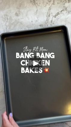 a person holding a baking pan with the words bang bang chicken bakes on it