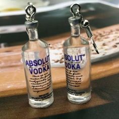 two empty vodka bottles sitting on top of a wooden table