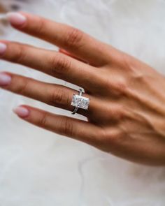 a woman's hand with a diamond ring on it