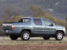 a silver truck parked in the middle of a field