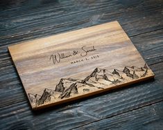 a wooden cutting board with mountains engraved on it