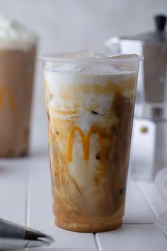 two iced drinks with whipped cream and mcdonald's logo on them