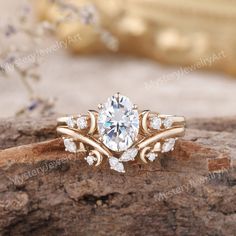 a close up view of an engagement ring on a piece of wood, with the center stone