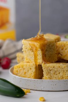 a stack of cornbreads with honey being drizzled over the top