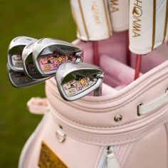 two golf clubs in a pink bag on the grass