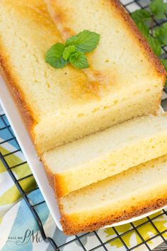 two slices of lemon pound cake on a cooling rack with fresh mint sprigs