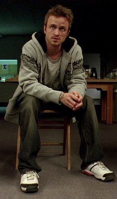 a man sitting on top of a wooden chair