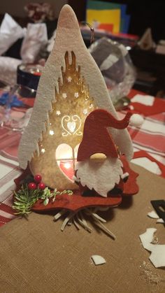 a small christmas decoration on top of a table with other decorations and lights around it