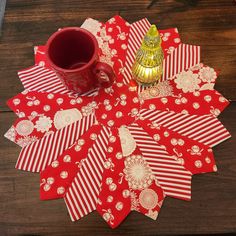 red and white table cloths with gold decorations on them sitting on a wooden surface