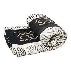 two black and white blankets folded on top of each other, one with an intricate design