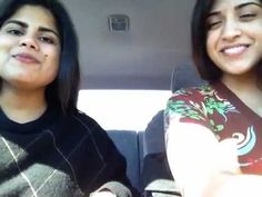 two women sitting in the back seat of a car