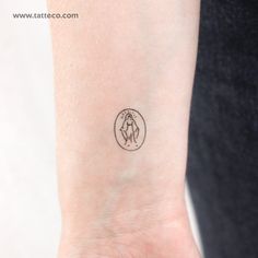 a woman's wrist with a small tattoo on the left side of her arm