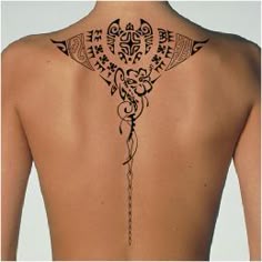 the back of a woman's neck with an intricate tattoo design on her lower back