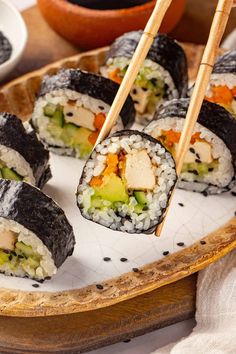 sushi on a plate with chopsticks ready to eat