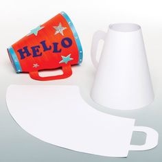 an orange and white cup next to a cut out paper cone with the word hello written on it