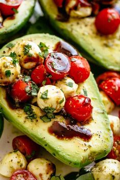 an avocado with tomatoes and other vegetables on it