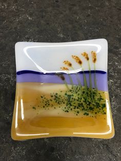 a yellow and blue plate with some plants on it