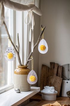 some yellow and white decorations hanging from a window sill