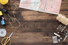 craft supplies laid out on a wooden table with scissors, thread, and other items