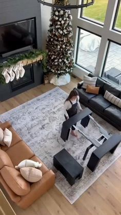 a living room filled with furniture and a fire place next to a large christmas tree