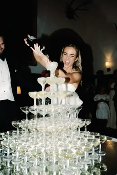 a bride and groom are standing in front of a cake with champagne glasses on it