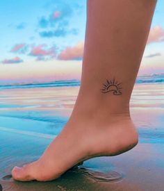 a woman's foot with a small sun tattoo on the side of her leg