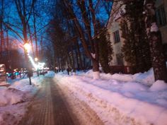 a snowy street at night with snow on the ground