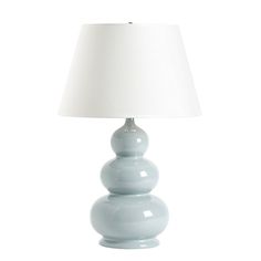 a light blue table lamp with a white shade on the top and bottom part of it