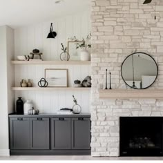 a living room with white brick fireplace and shelves