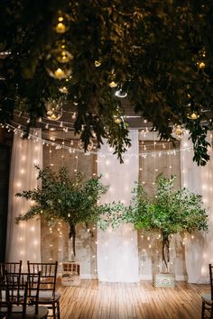 an indoor wedding setup with greenery and string lights