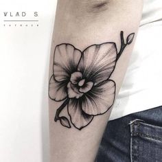 a black and white flower tattoo on the left arm by wild's tattoo studio