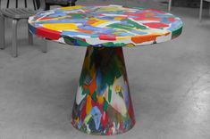 a multicolored table with chairs in the background