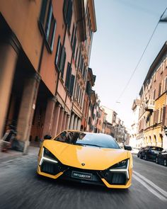 a yellow sports car is driving down the street