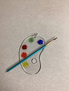 a crochet hook with beads and a paintbrush