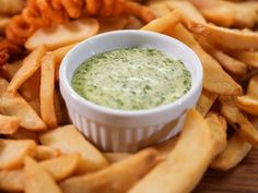 a bowl of dip surrounded by french fries