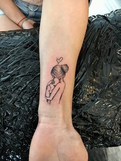 a woman's arm with a tattoo on it that has a girl holding a heart