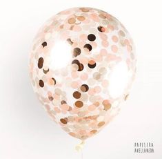 a pink and gold balloon with confetti on the inside is being held by a string