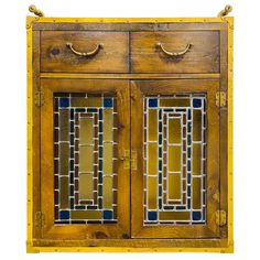 an old wooden cabinet with two doors and stained glass inserts on the front door