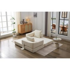 a living room with white furniture and wood floors