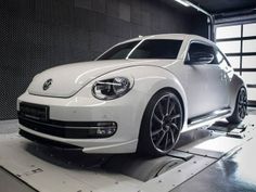 a white volkswagen beetle parked in a garage