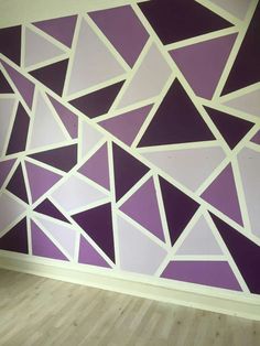 a purple and white wall with triangles painted on it