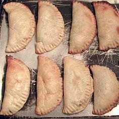 nine pastries are lined up on a baking sheet to be baked in the oven