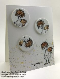 three buttons on a white card with gold splats and some designs in the middle