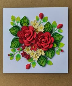 a white card with red flowers and green leaves