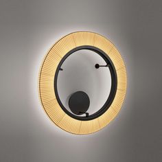 a circular light fixture mounted on the side of a wall with a dimmer in front of it