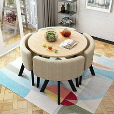 a round table with four pink chairs around it on a rug in a living room