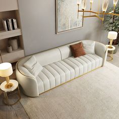 a living room with a white couch and two lamps on either side of the couch