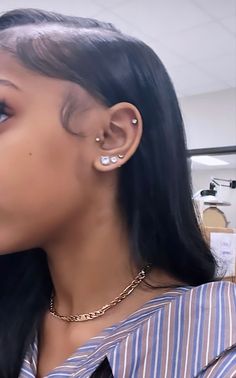 a close up of a person with ear piercings on their ears and wearing a striped shirt