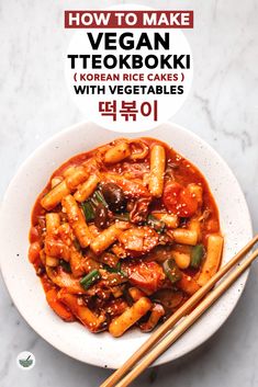 a white bowl filled with noodles and vegetables next to chopsticks