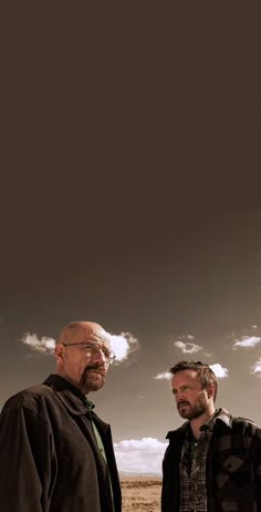 two men standing next to each other in the desert